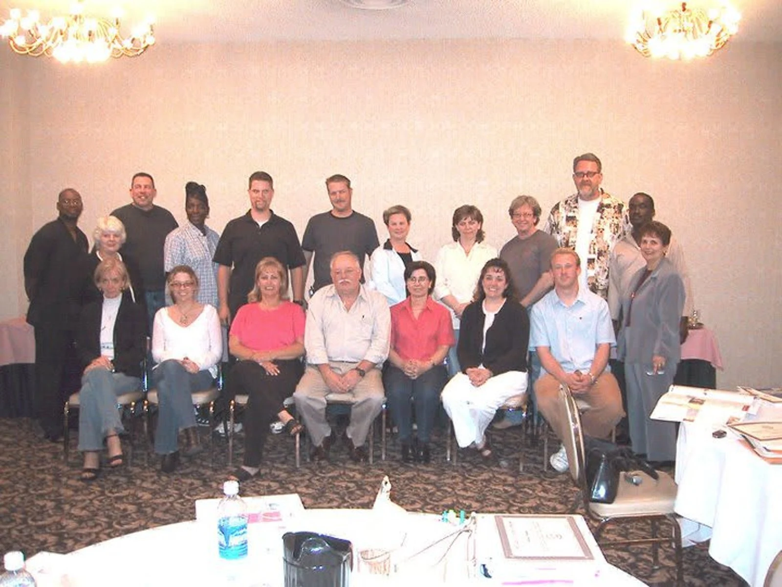 Photo of a woman in a lab coat and protective equipment holding a vile up to a digital machine and a white version of the GSK logo superimposed in the middle foreground